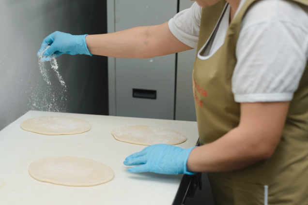 Dusting flour over dough rounds